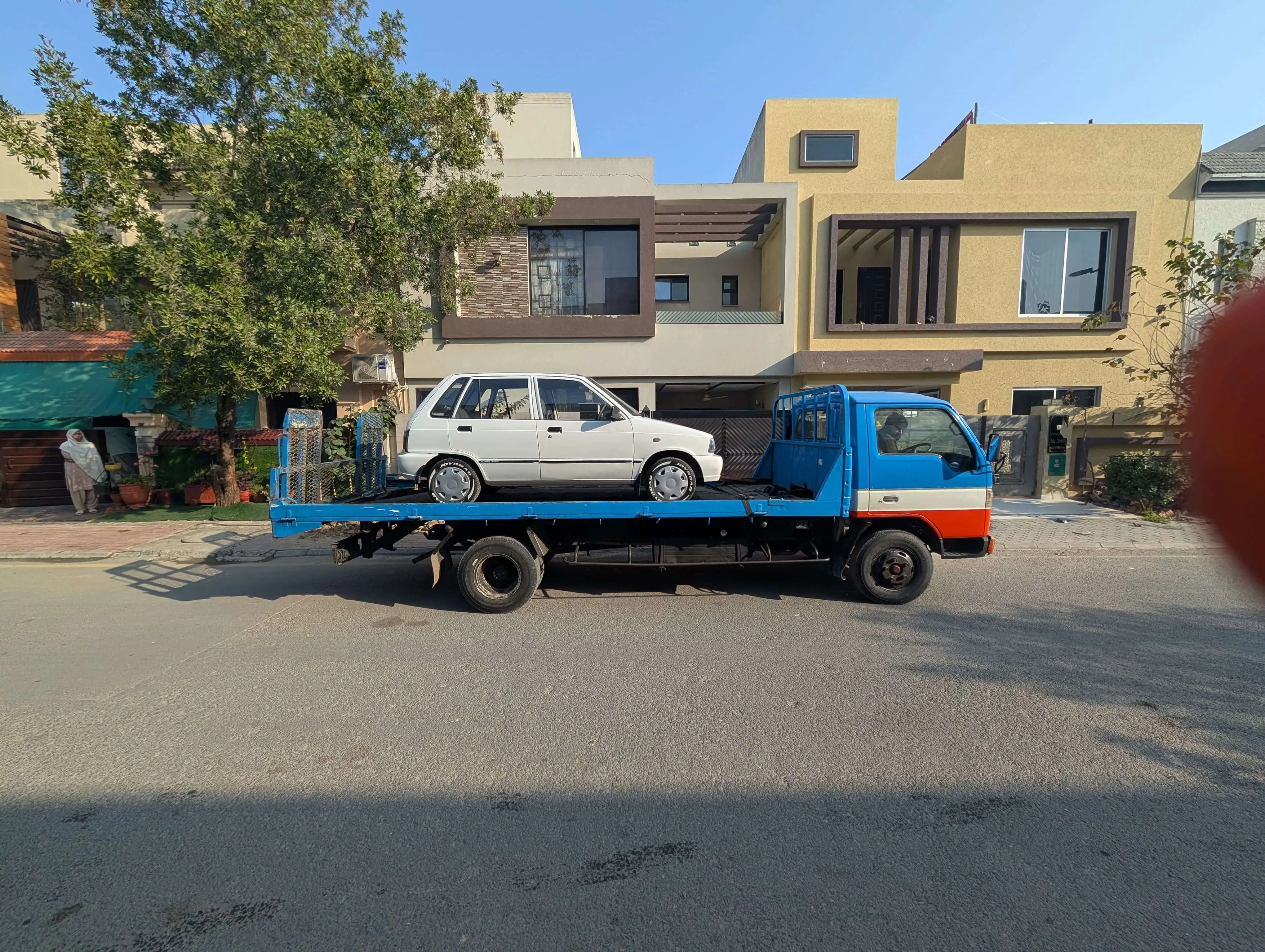 Flatbed tow truck transporting a vehicle safely