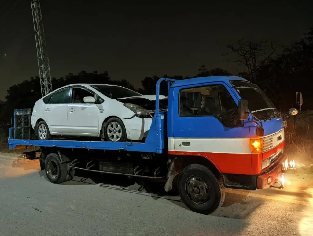 Tow truck recovering broken car in Lahore